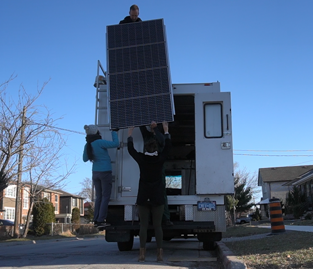 Our friendly neighbours helping us lift up the rack of solar panels. We couldn't have done it alone.