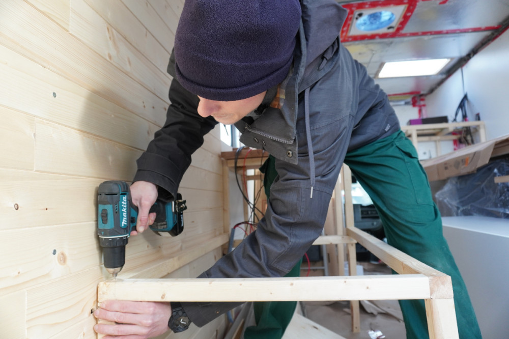 Moritz building our left bench frame in the camper.