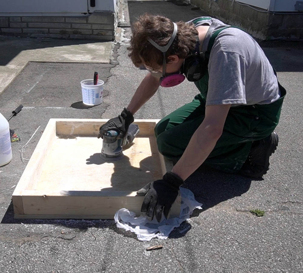 An orbital sander has enough power to sand down air bubbles and overhanging resin.